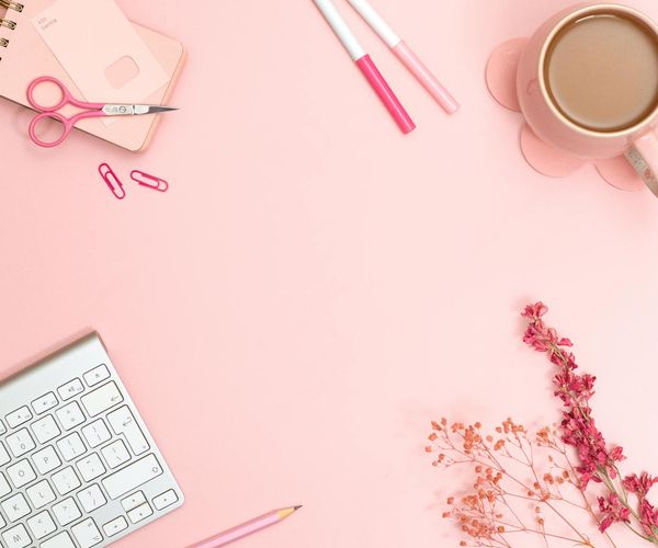 A calm and organized desk space with a cup of tea and a notebook.